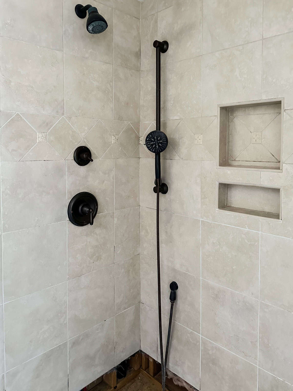 The existing shower and travertine tile in the primary bathroom